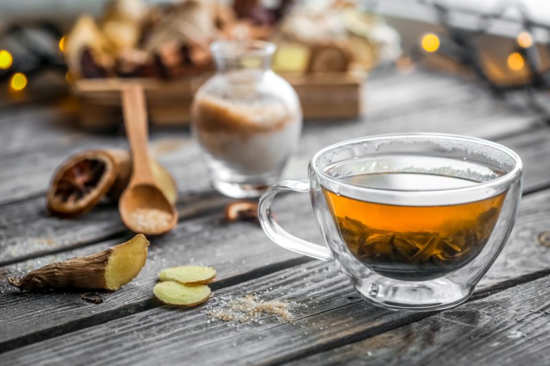 still life with transparent and fragrant Cup of tea with ginger on wooden background