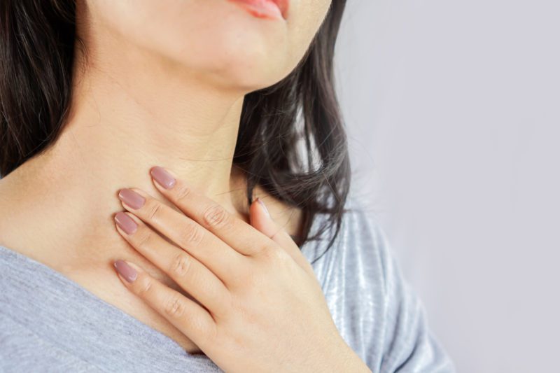 Woman rubbing skincare onto her neck area